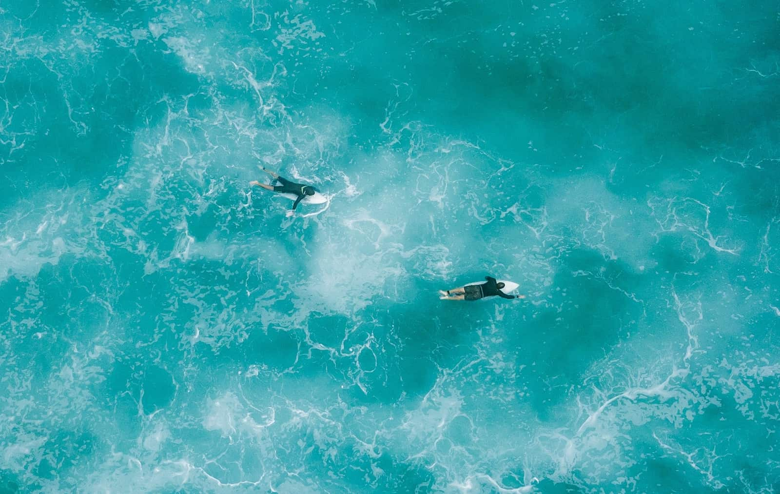 surfers paddling out